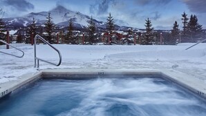 A hot tub in a snowy outdoor setting with a mountainous backdrop. - Easy Shuttle Access | Resort Amenities (Big Sky)