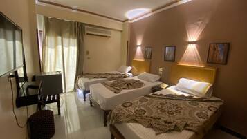 Une chambre d’hôtel avec deux lits, un bureau et une télévision.