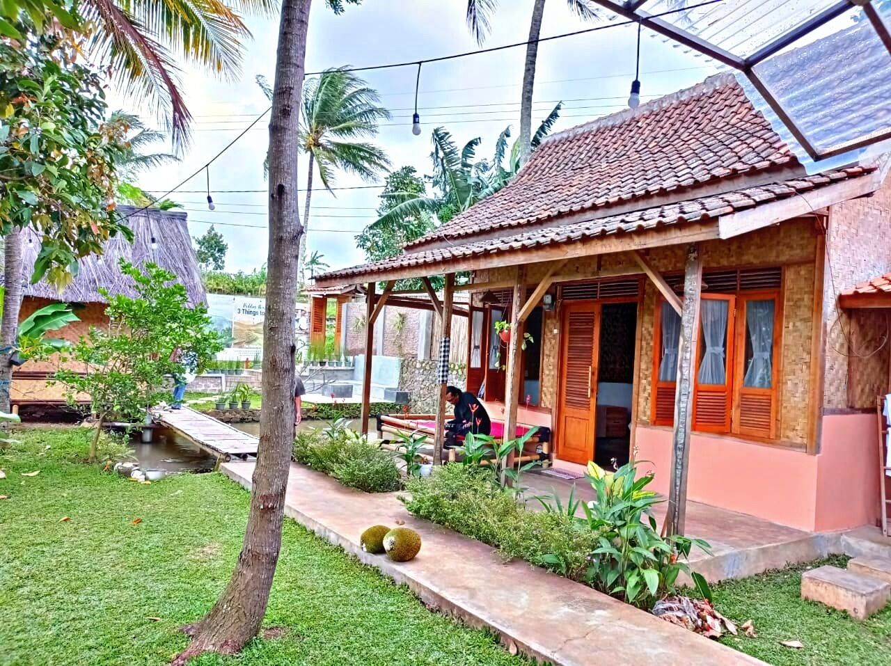 A traditional house with a tiled roof, a porch, and a small garden area with a pathway.