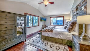 A bedroom with a bed, dresser, ceiling fan, and a large window. - Luxury Mountain Retreat | Walk to Heavenly | TW504 (South Lake Tahoe)