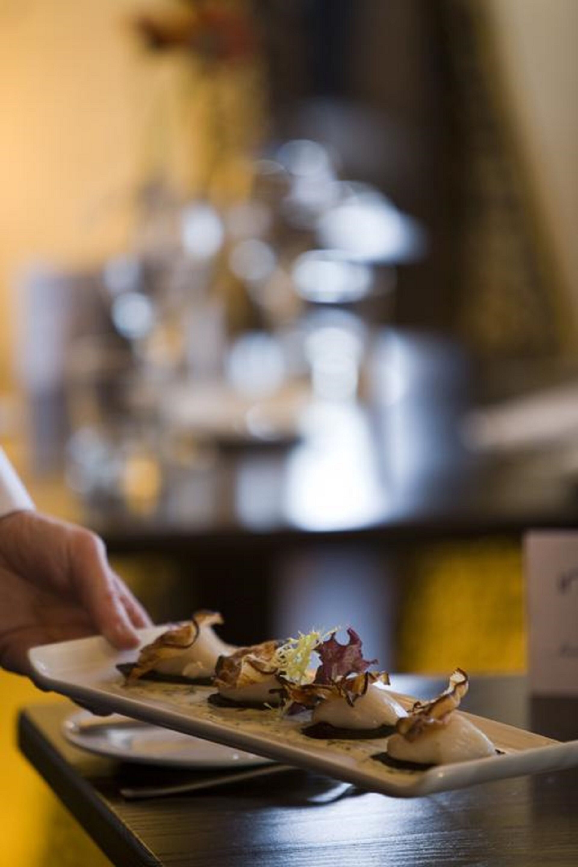 A person serving a dish on a rectangular plate.