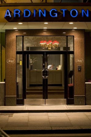 L’extérieur d’un hôtel appelé « ARDINGTON », avec une entrée moderne caractérisée par des portes en verre et une enseigne bien visible.