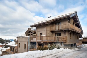 A multi-story wooden building with balconies, surrounded by snow.