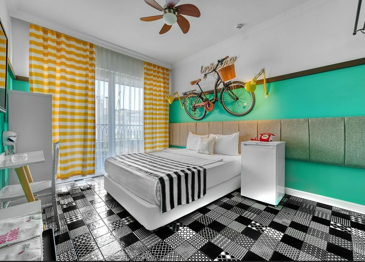A modern bedroom with a bed, a bedside table, a mirror, and a bicycle wall decoration.