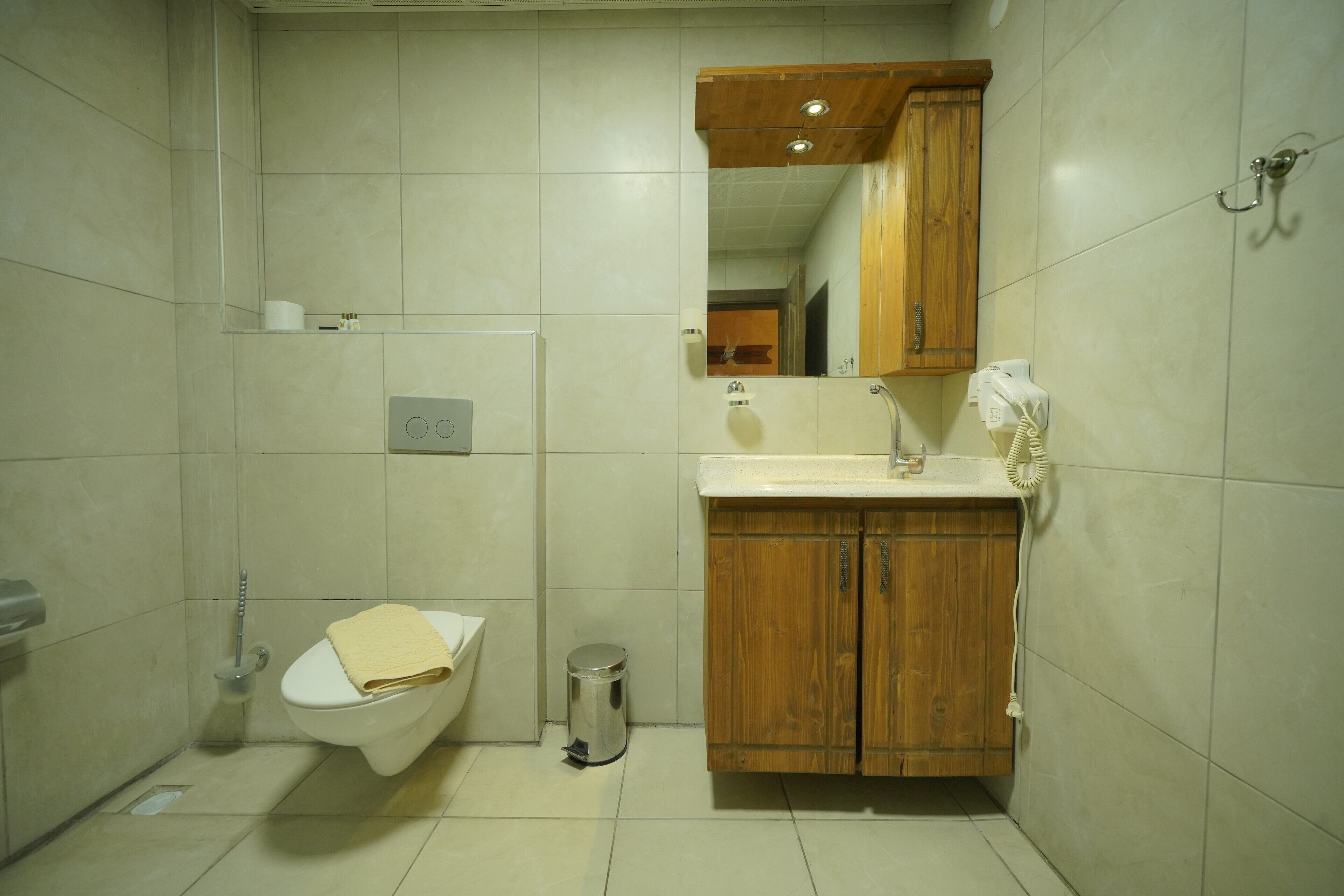 A small bathroom with a toilet, sink, and mirror.