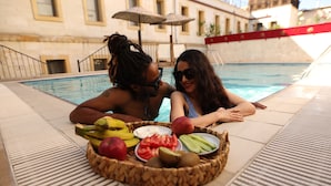 Escena junto a la piscina con una cesta de frutas y una alberca.