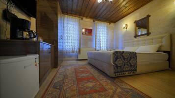 A cozy room with a bed, a coffee maker, and a radiator.