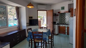 Una cocina compacta con una mesa, sillas y un televisor.