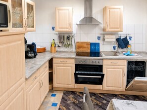 A kitchen with wooden cabinets, a stove, oven, and a dishwasher.