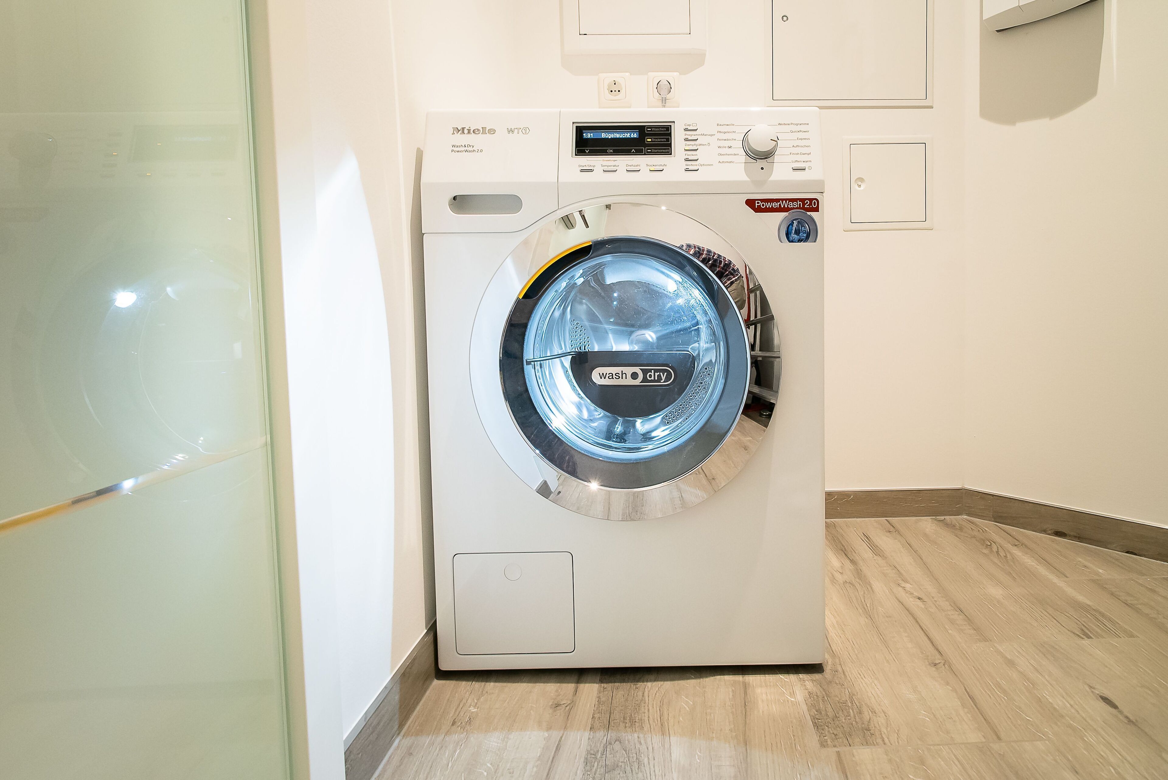 A front-loading washing machine with a digital display, control panel, and a 'PowerWash 2.0' label.