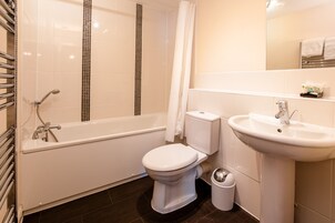 Un baño moderno con bañera, inodoro y lavamanos.