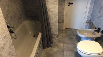 Un bagno con vasca, water e bidet.