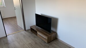 Uma sala de estar moderna com um painel de madeira que acomoda uma televisão de tela plana.