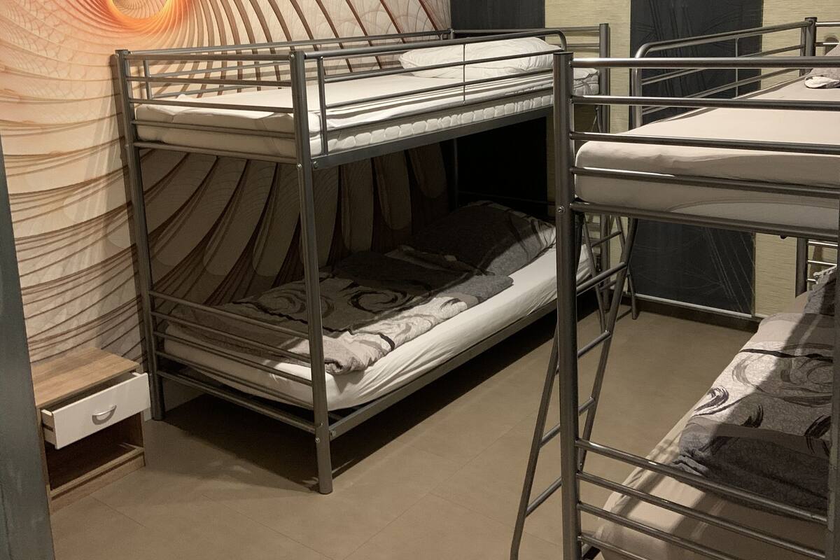 A bunk bed room with a spiral wall design and a mirror on the wall.