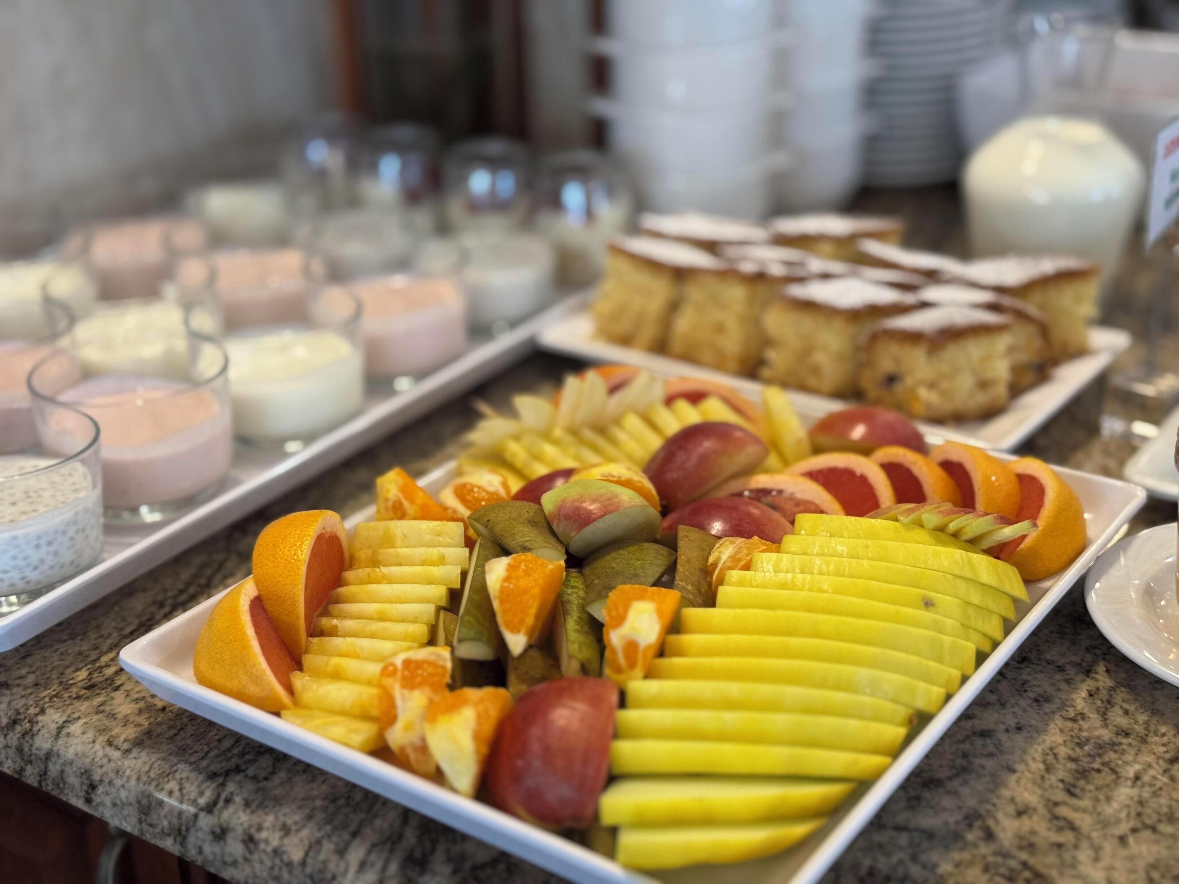 Buffet com diversas frutas e sobremesas.