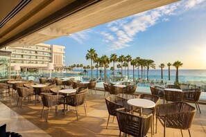 A rooftop terrace with outdoor seating and a view of the ocean.