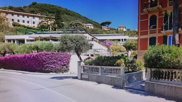 A street with buildings, a staircase, and a purple flower bed. - WHITE & BLUE HOUSE (Chiavari)