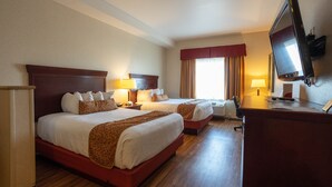 Een hotelkamer met twee bedden, een televisie en een bureau met een computer.