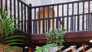 A staircase with a wooden railing and stone walls, surrounded by lush green plants. - Palacio de Orisoain (Orísoain)