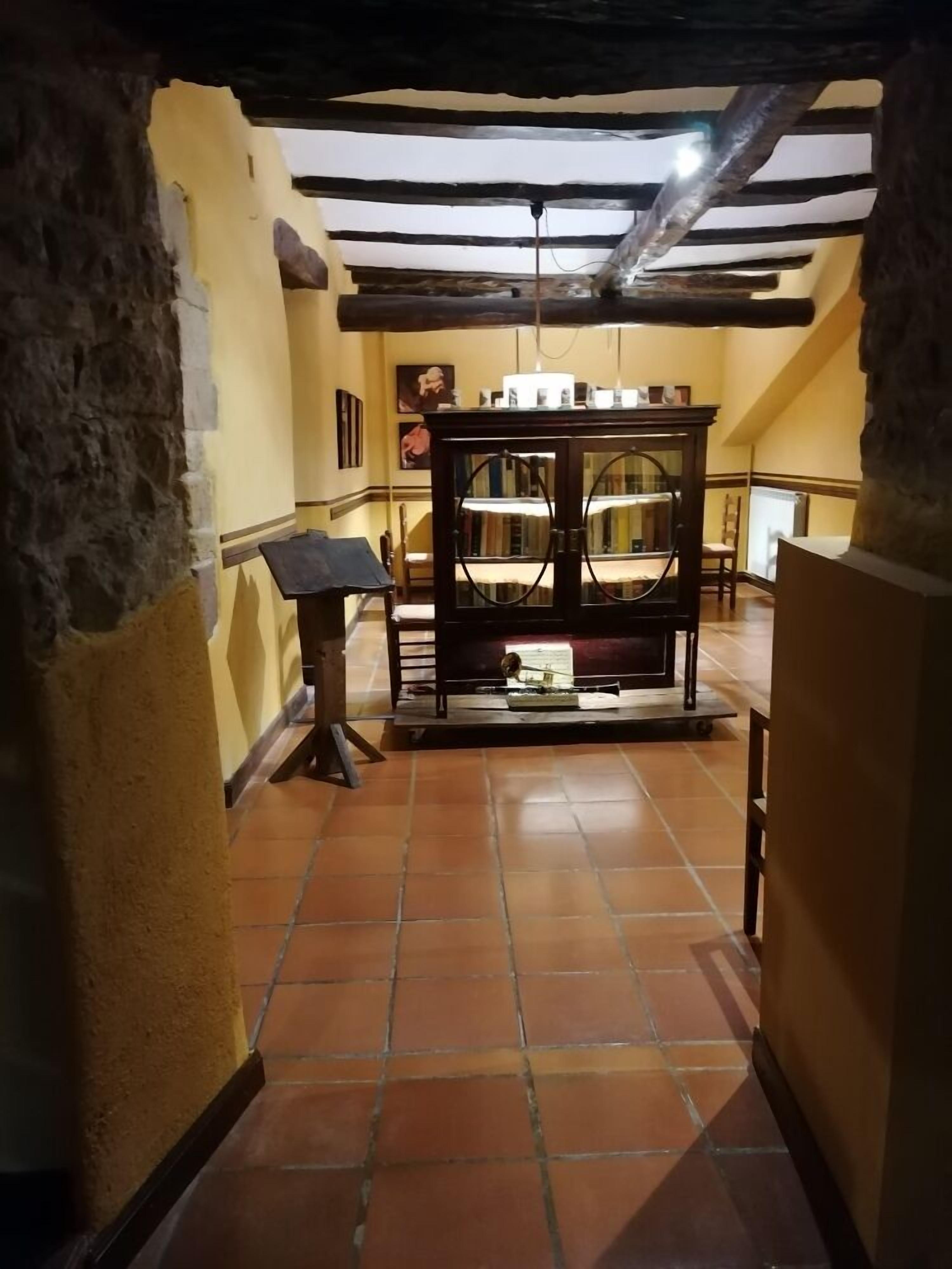 Ein schmaler Korridor mit Fliesenboden, einem Holztisch mit Glasplatte und einer Steinwand an einer Seite.