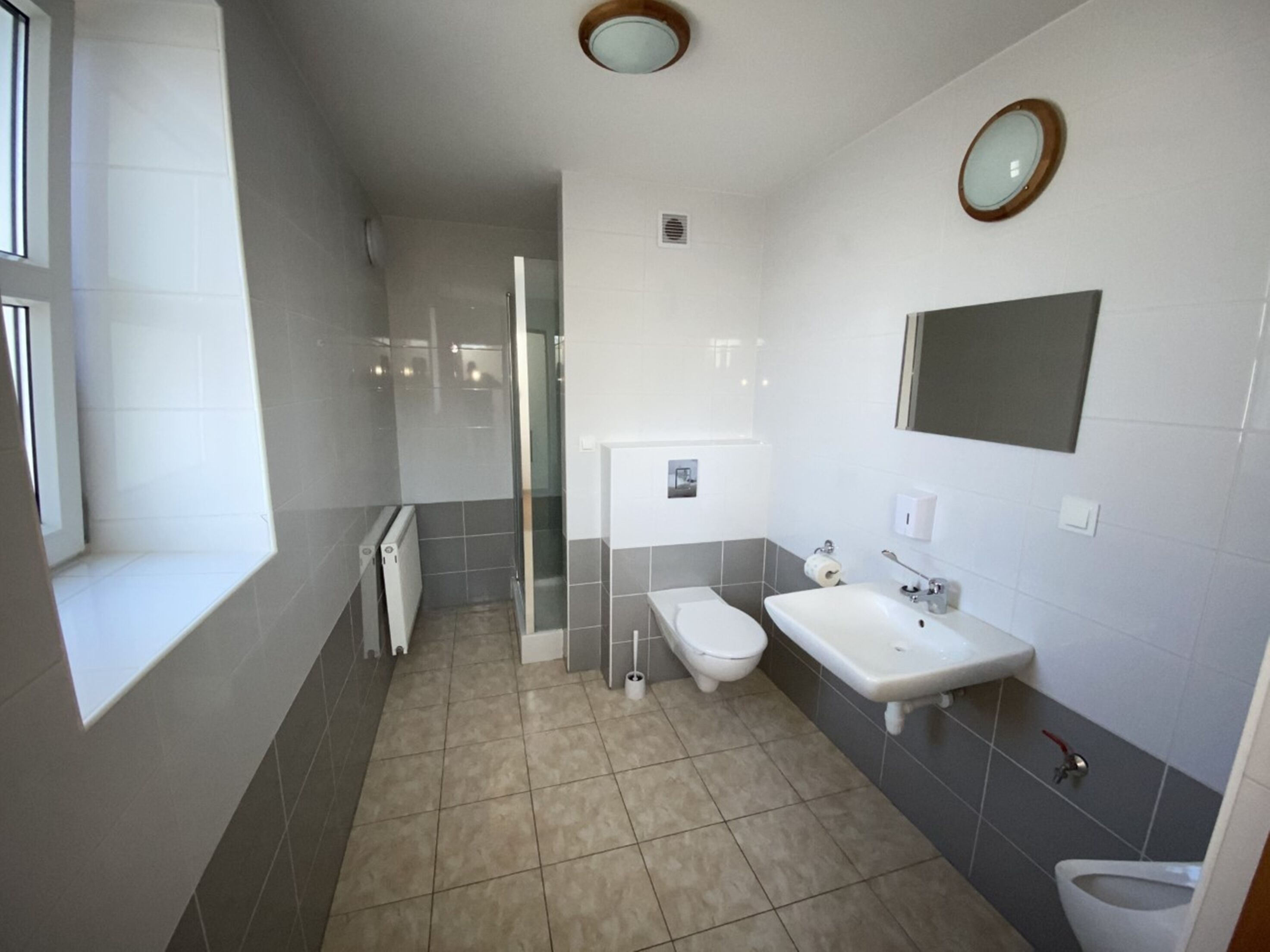 A modern bathroom with a shower, toilet, and sink.