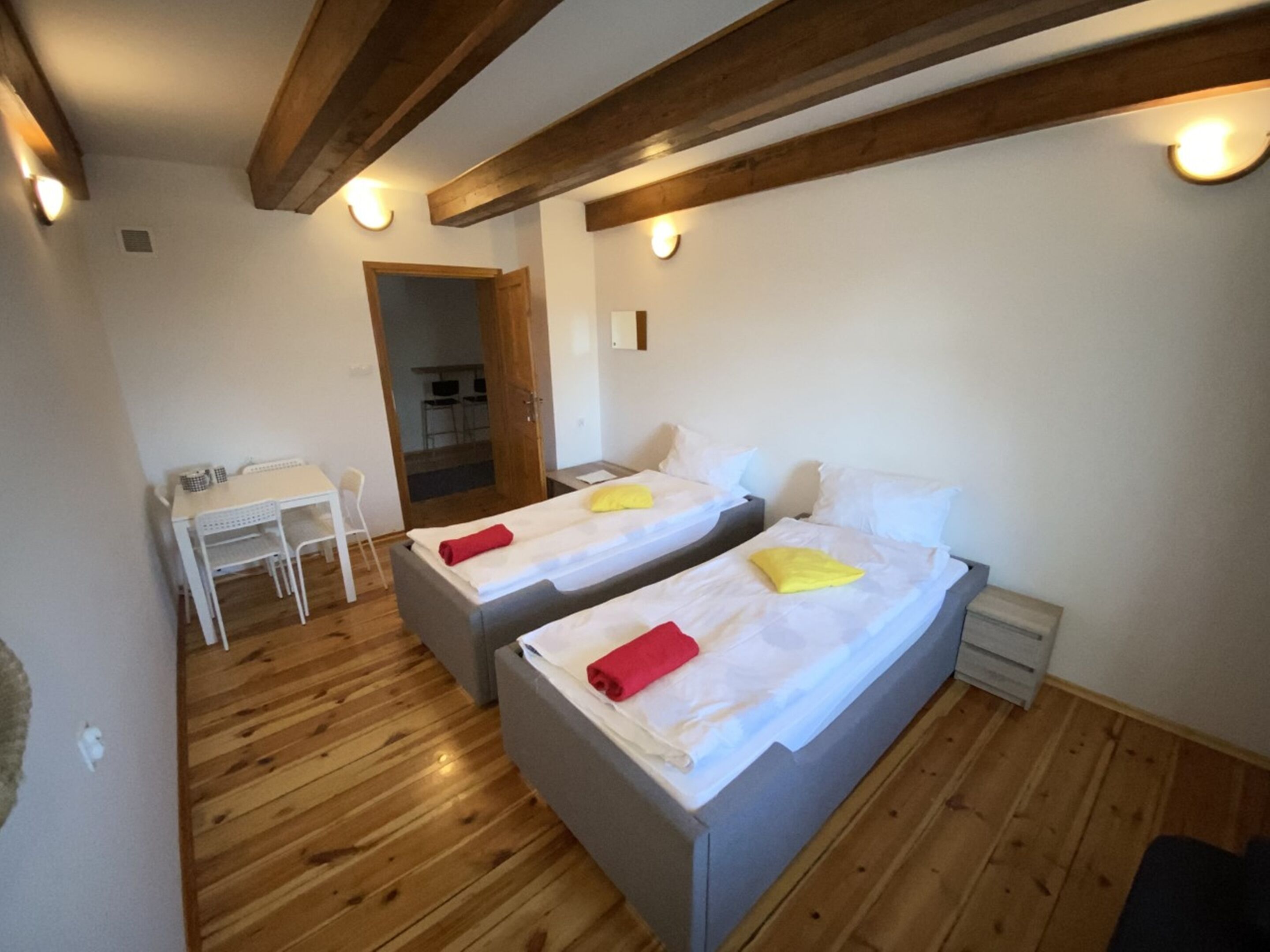 A room with two beds, a desk, and a chair.