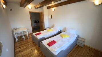 A room with two beds, a desk, and a chair.