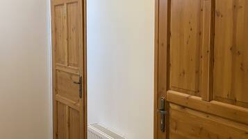 Un pasillo con puertas de madera y un radiador blanco.