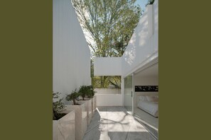 A modern bedroom with a large window, a bed, and a view of trees. - Casa Rombos By Grupo Encanto Rombo II (Mexico City)