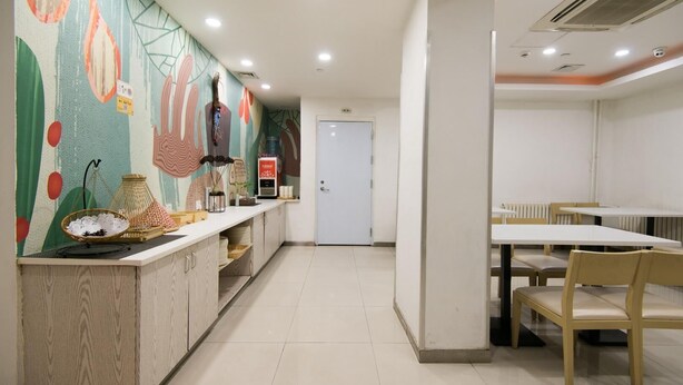 A restaurant with a counter, chairs, and a door in the background.