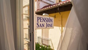 A sign for 'Pension San José' with a view of a building and a balcony. - Pensión San José (Granada)