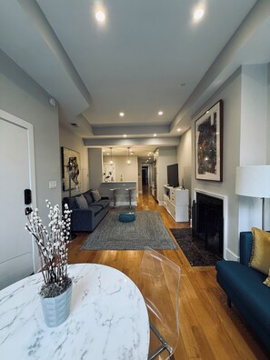 A modern living room with a sofa, a coffee table, and a fireplace. - Dupont 5-Star, Walk Score 94, Metro, 2BR (Washington)