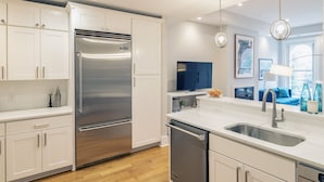 A modern kitchen with white cabinetry, stainless steel appliances, a dishwasher, and a large sink. - Dupont 5-Star, Walk Score 94, Metro, 2BR (Washington)