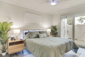 A bedroom with a bed, nightstands, lamps, and potted plants. - < 2 Mi to Coast: St Pete Beach Gem w/ Pool Access (St Pete Beach)