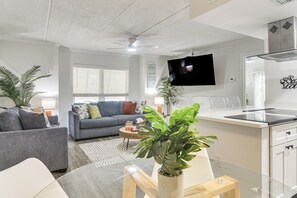 Un salon moderne avec un canapé, une table basse et un téléviseur.