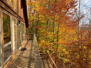 A wooden deck with a railing, overlooking a forest with autumn foliage. - Zigadeaux - Hot Tub, Wood Burning Fireplace (Davis)