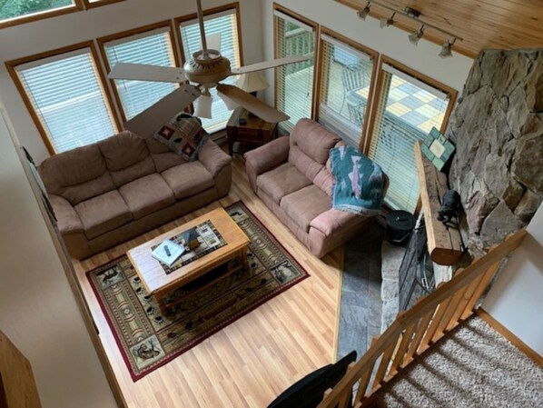 A spacious living area with a sofa set, a coffee table, and a fireplace.