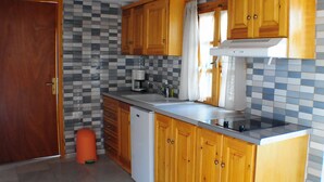 Una cocina con armarios de madera, un lavabo, una cafetera y un lavavajillas.