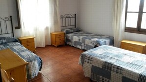 A dormitory room with two beds, wooden nightstands, and a window with curtains. - HOUSE OF LA VIÑA, ALMACHAR 8 PERS (Almáchar)