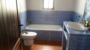 A bathroom with a bathtub, toilet, and sink. - HOUSE OF LA VIÑA, ALMACHAR 8 PERS (Almáchar)