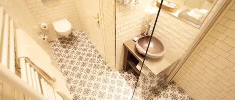 Un baño con inodoro, lavabo y baldosas de suelo estampadas.