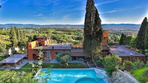 Une villa dotée d’une piscine, d’une terrasse et offrant une vue sur la ville et les montagnes.