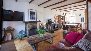 A cozy living room with a fireplace, wooden furniture, and a flat-screen TV.