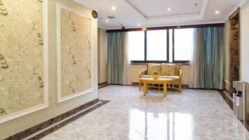 A spacious room with a marble floor, a sofa, and a window with curtains.