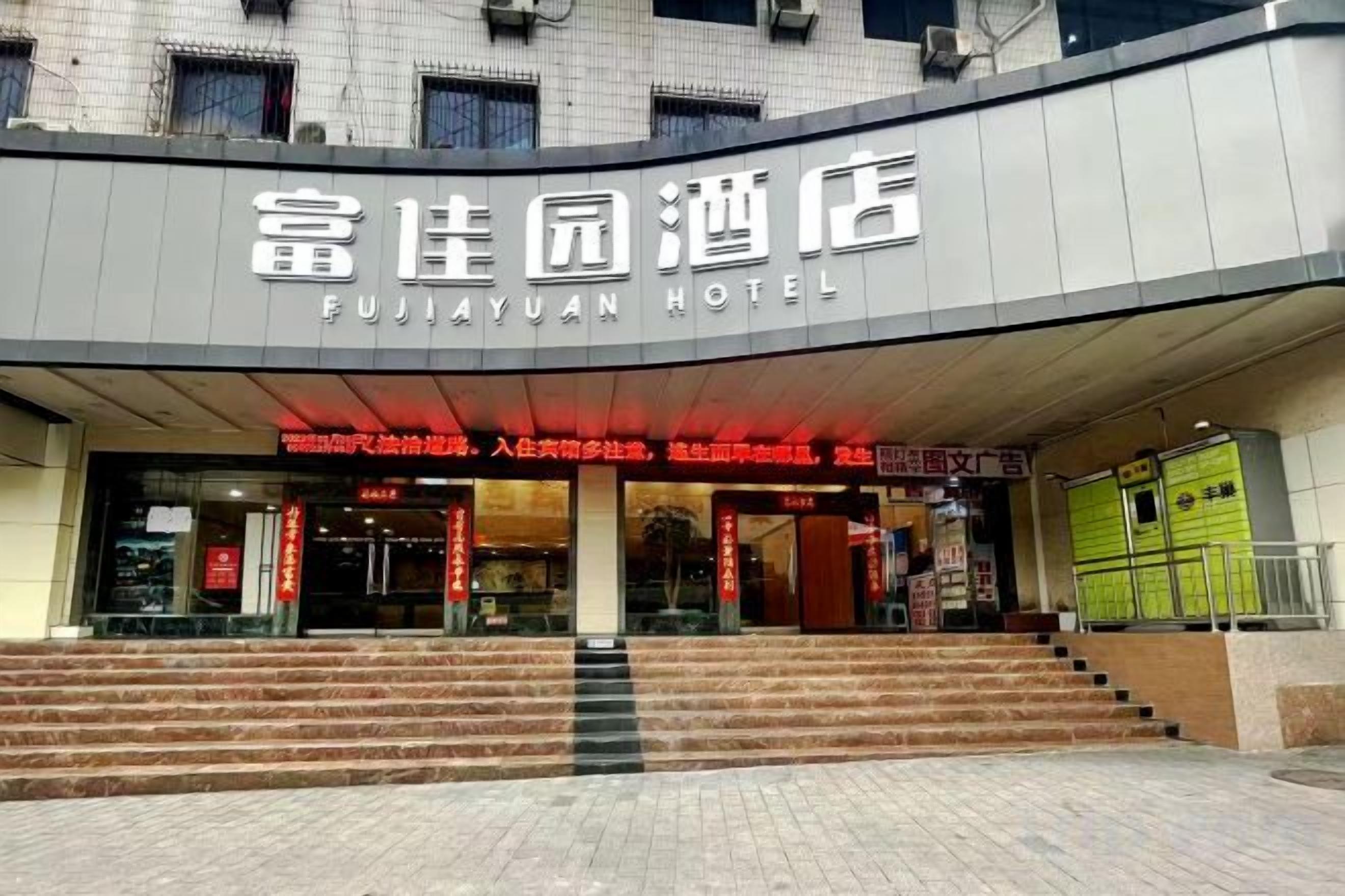 The entrance to the Fujiyuan Hotel with a modern facade and a staircase leading up to the entrance.