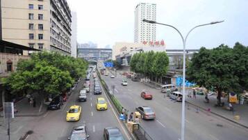 A busy urban street with multiple lanes of traffic, including cars and taxis.