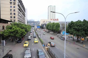 Una concurrida calle urbana con varios carriles de tráfico, incluyendo automóviles y taxis.