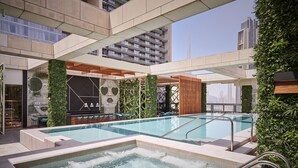 Un área de piscina en la azotea con jacuzzi, asientos y follaje.