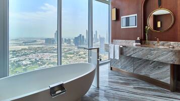 Une salle de bain moderne avec une baignoire sur pieds, un meuble-lavabo en marbre, un grand miroir et une vue sur la ville.