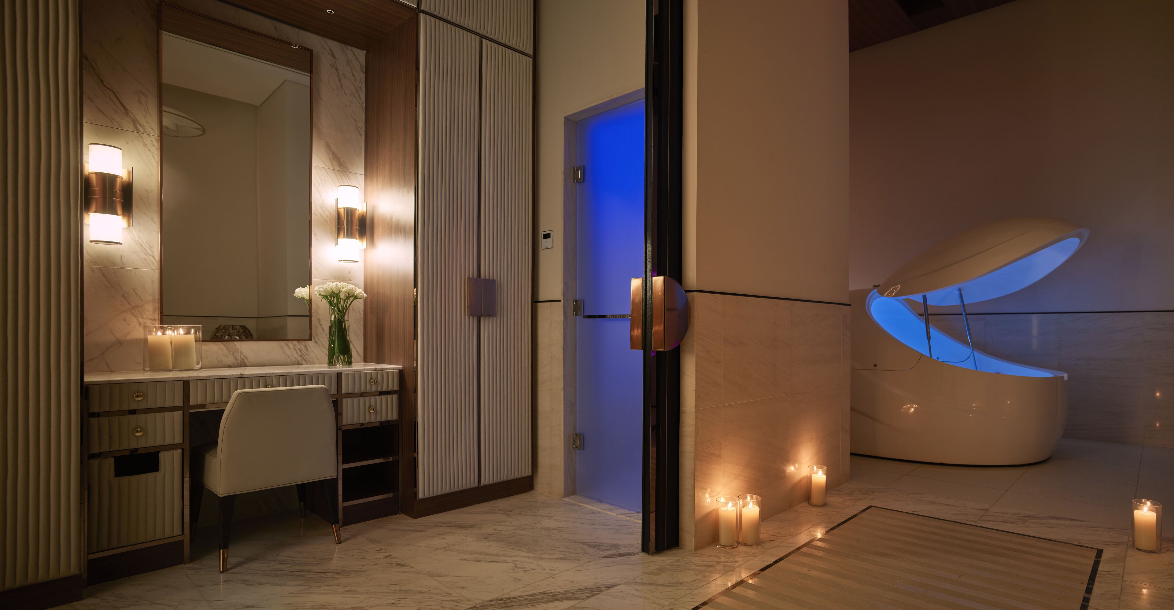 A modern bathroom with a vanity, mirror, and candles.